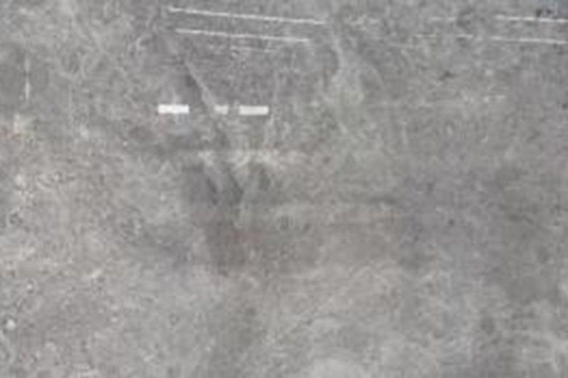 طاولة قهوة رخامية مضلعة باللون الرمادي مع أريكة طويلة